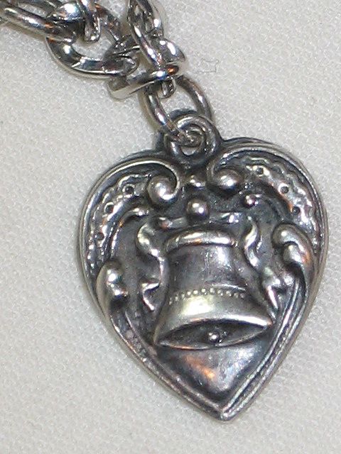 Sterling Silver Puffy Heart Charm with Repousse Bell and Ribbon Engraved 'Grandma L." Sterling Silver Puffy Heart Charm with Repousse Bell and Ribbon Engraved 'Grandma L."