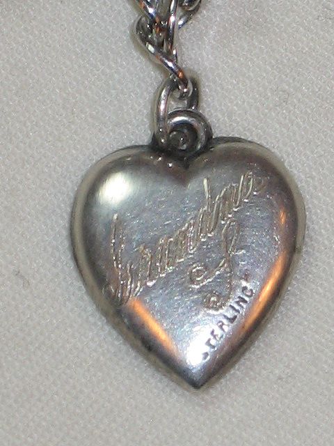 Sterling Silver Puffy Heart Charm with Repousse Bell and Ribbon Engraved 'Grandma L." Sterling Silver Puffy Heart Charm with Repousse Bell and Ribbon Engraved 'Grandma L."