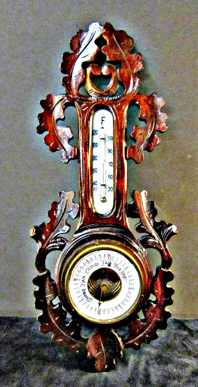 A Vintage Black Forest Carved Walnut Barometer and Thermometer A Vintage Black Forest Carved Walnut Barometer and Thermometer
