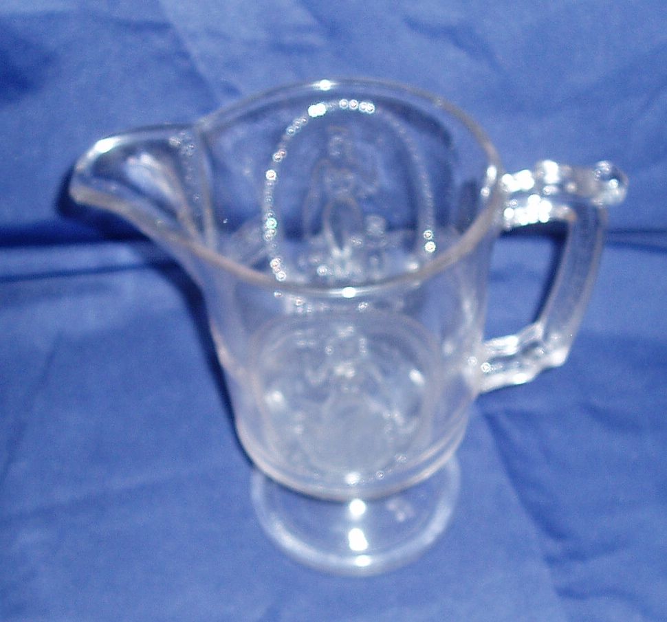 Antique colorless eapg cupid and venus guardian angel milk pitcher Antique colorless eapg cupid and venus guardian angel milk pitcher
