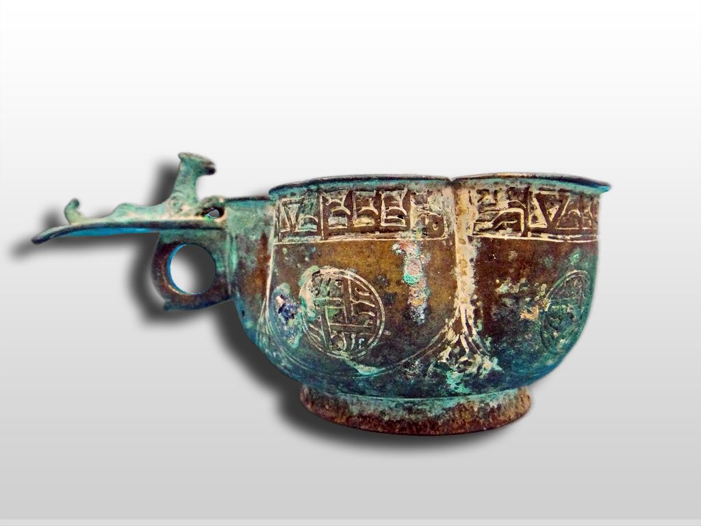 A Seljuk Bronze Lobed cup with layed lion on ringed handle 12th Century A Seljuk Bronze Lobed cup with layed lion on ringed handle 12th Century