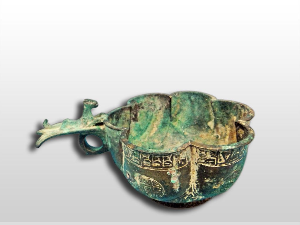 A Seljuk Bronze Lobed cup with layed lion on ringed handle 12th Century A Seljuk Bronze Lobed cup with layed lion on ringed handle 12th Century