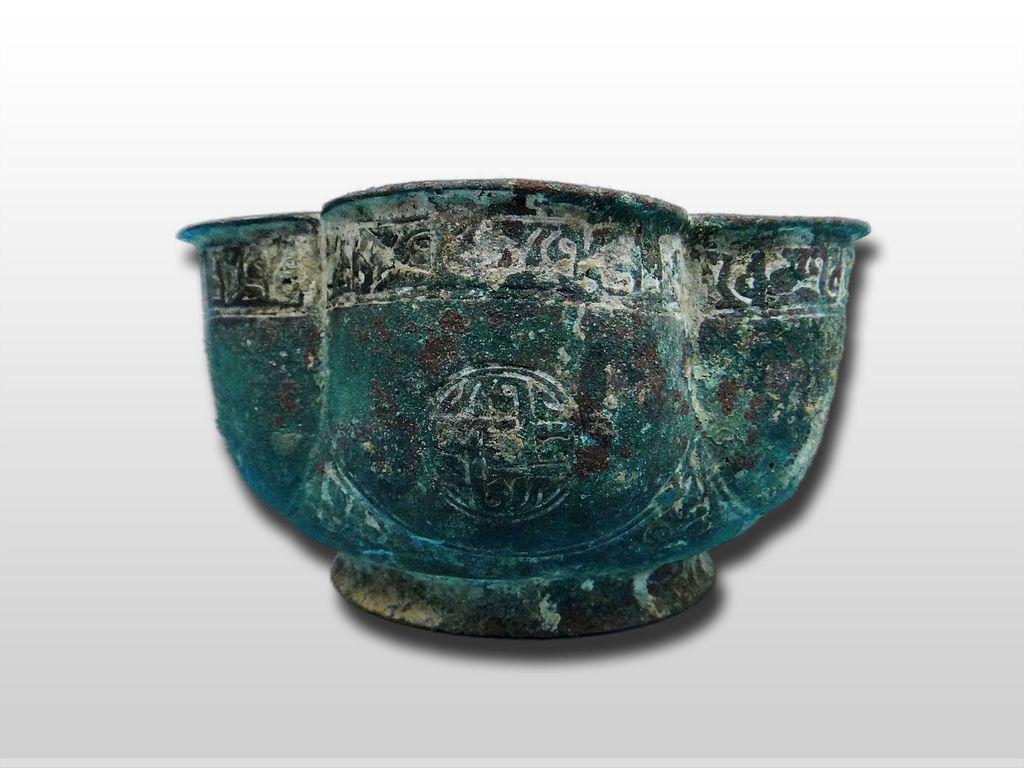 A Seljuk Bronze Lobed cup with layed lion on ringed handle 12th Century A Seljuk Bronze Lobed cup with layed lion on ringed handle 12th Century