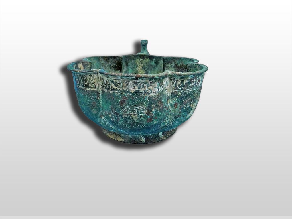 A Seljuk Bronze Lobed cup with layed lion on ringed handle 12th Century A Seljuk Bronze Lobed cup with layed lion on ringed handle 12th Century