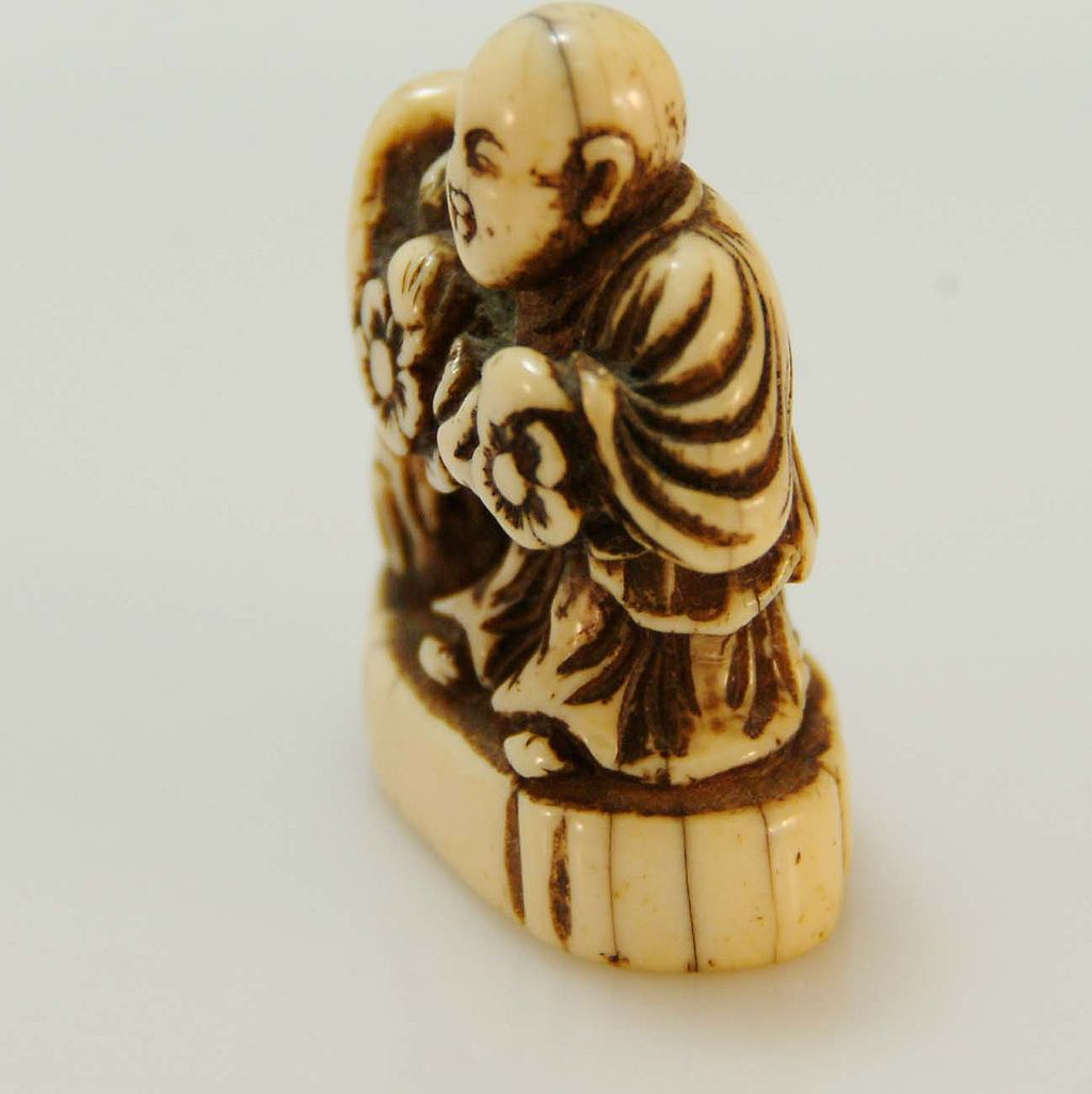 Carved Ivory Netsuke of Man with Flowers c. 19th C. Carved Ivory Netsuke of Man with Flowers c. 19th C.