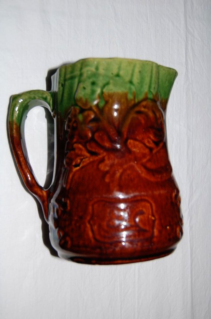 Early 1900's Glazed Pottery Pitcher with Raised Floral Design Early 1900's Glazed Pottery Pitcher with Raised Floral Design