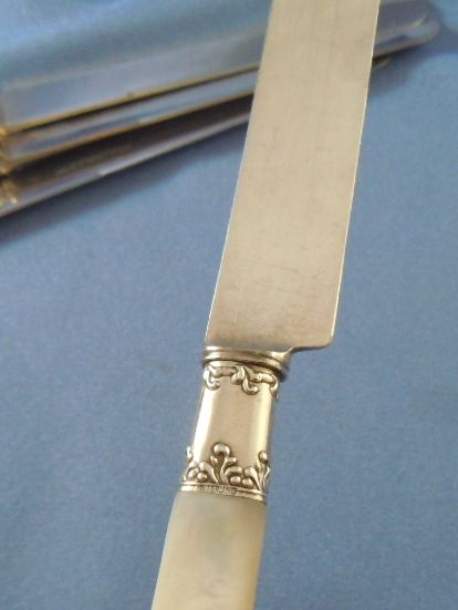 Mother of pearl dinner knives sterling ferrules (4) Mother of pearl dinner knives sterling ferrules (4)