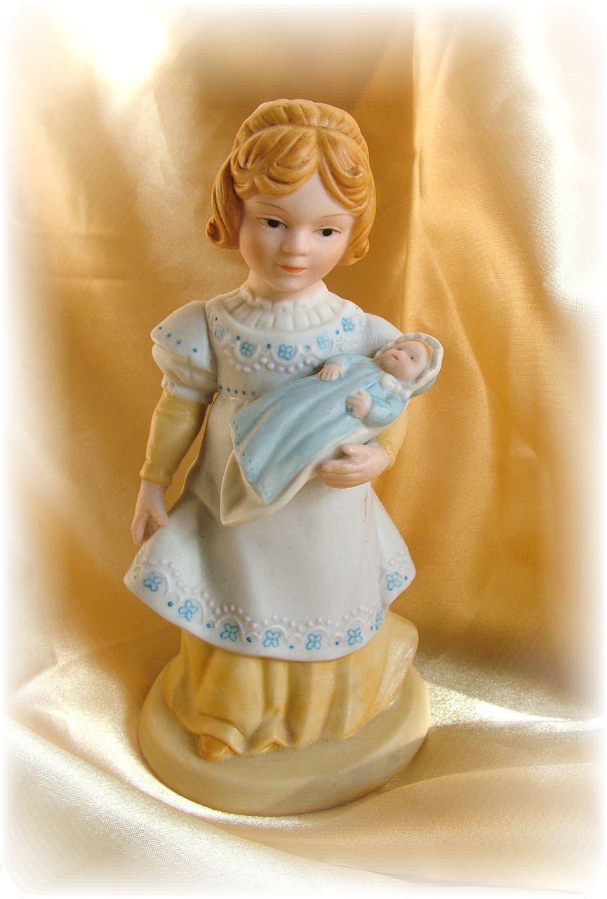 Vintage old fashioned little girl with doll figurine Vintage old fashioned little girl with doll figurine