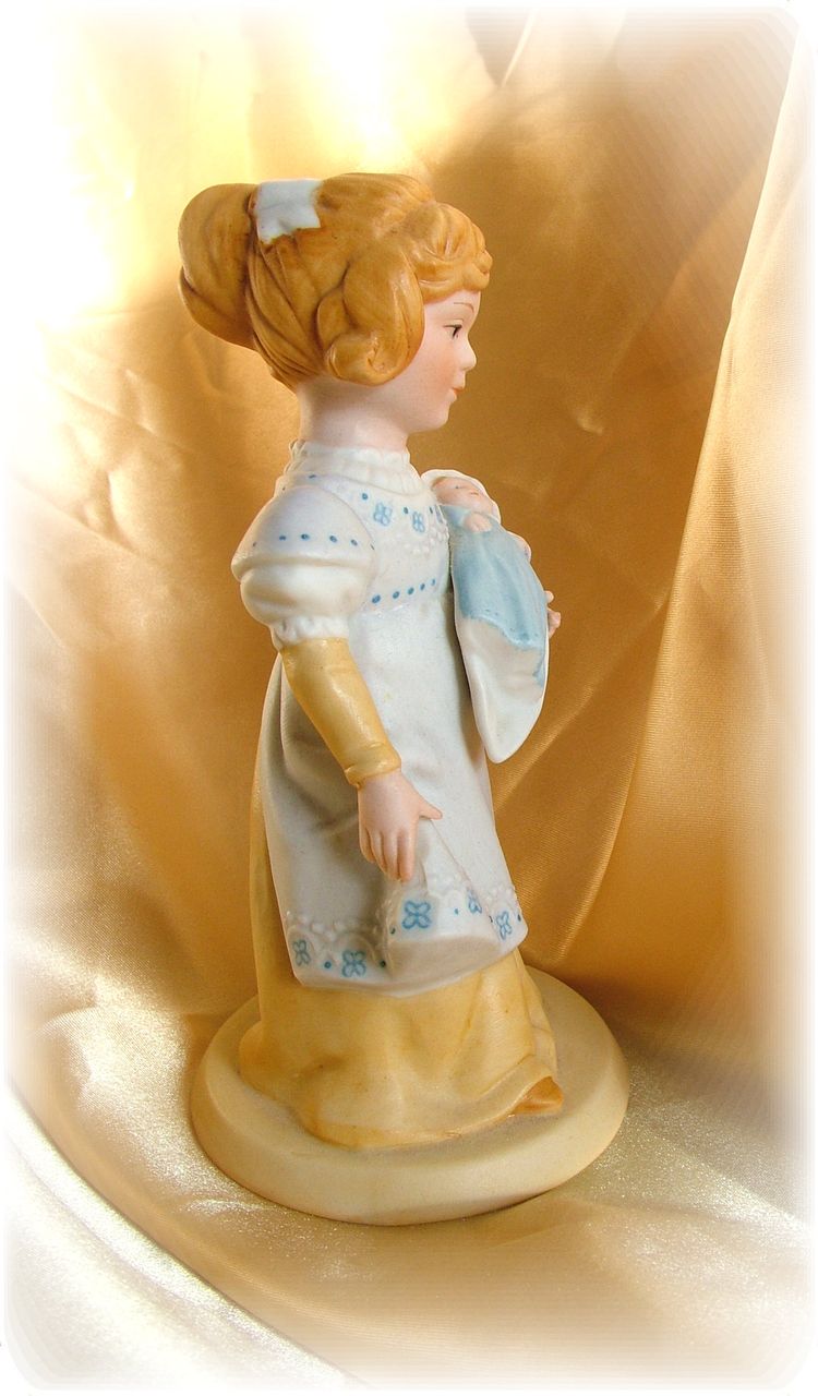 Vintage old fashioned little girl with doll figurine Vintage old fashioned little girl with doll figurine